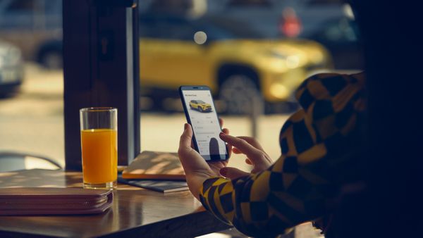 Junge Frau im Café beim Anschauen eines Angebots auf ihrem Smartphone