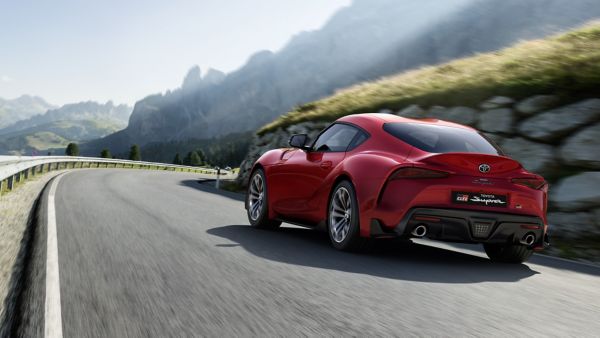 Ein roter Toyota GR Supra fährt dynamisch eine kurvige Bergstraße entlang und steht sinnbildlich für die Flexibilität eines Auto Abos.