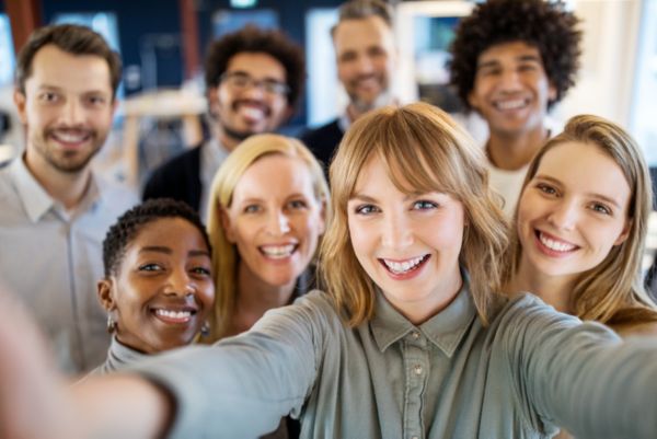 Lachende Mitarbeiter beim aufnehmen eines Selfies