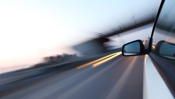 Die Aufnahme zeigt den Blick aus einem fahrenden Auto mit starker Bewegungsunschärfe.