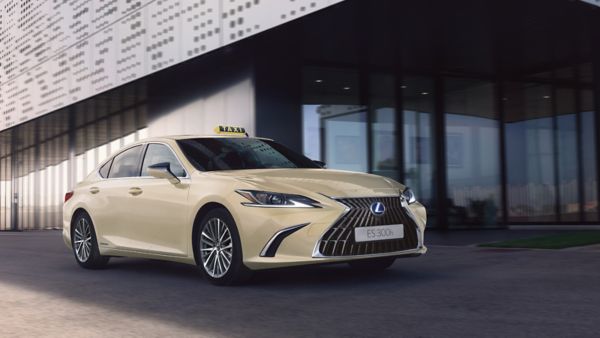 Ein Lexus Taxi parkt vor einem modernen Gebäude mit Glasfassade