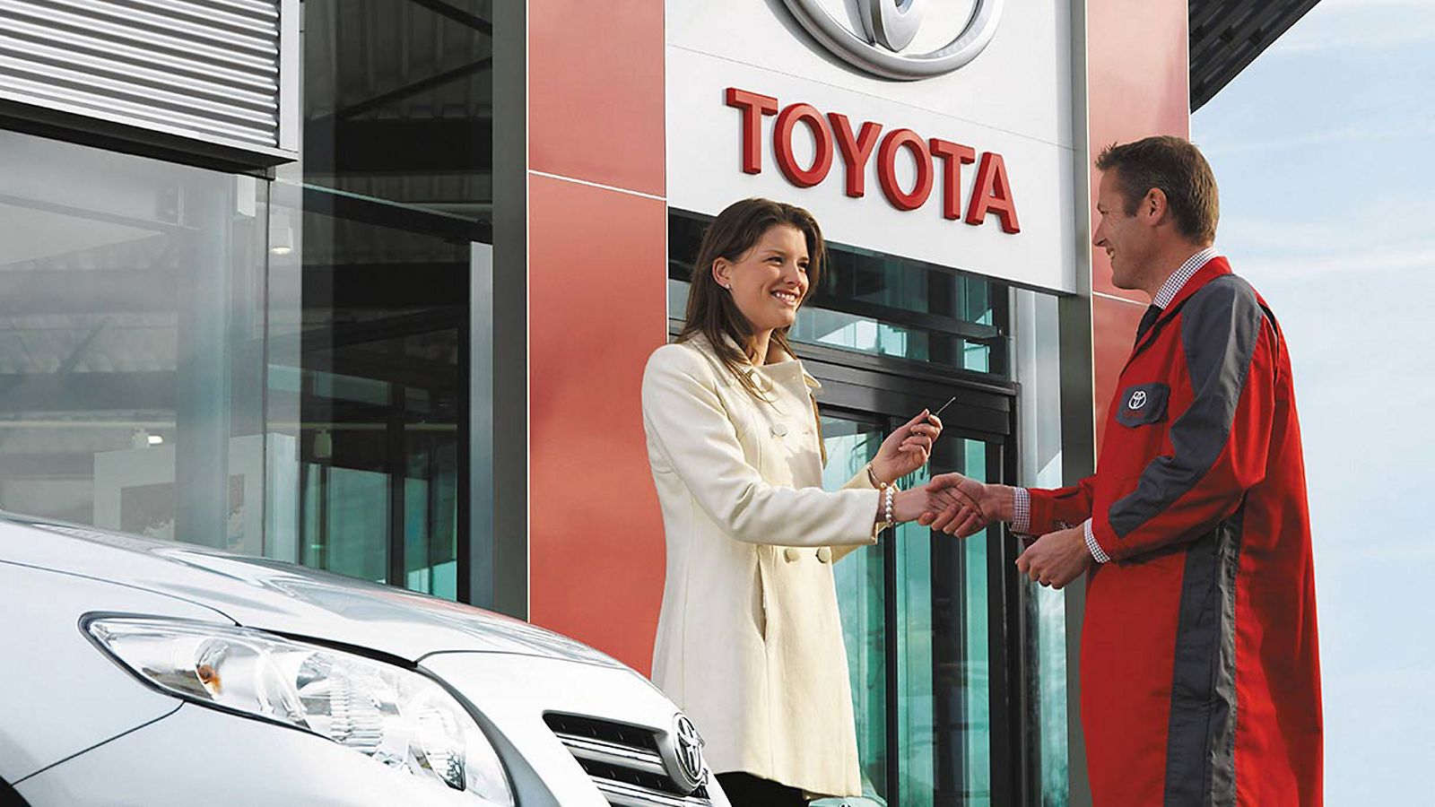 Toyota Service Mitarbeiter und eine Kundin bei der Schlüsselübergabe