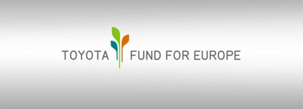 Schrift-Logo des „Toyota Fund for Europe“ mit stilisierter grüner, orangefarbener und blauer Pflanze, die Wachstum und Nachhaltigkeit symbolisieren