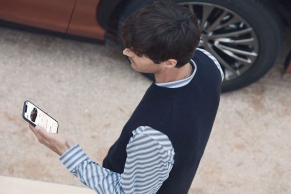 Eine Person blickt auf ein Smartphone auf dem die Lexus Link App zu sehen ist