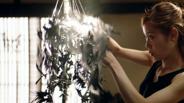 Eine Takumi Handwerkskünstlerin arbeitet konzentriert an einem Kunstwerk