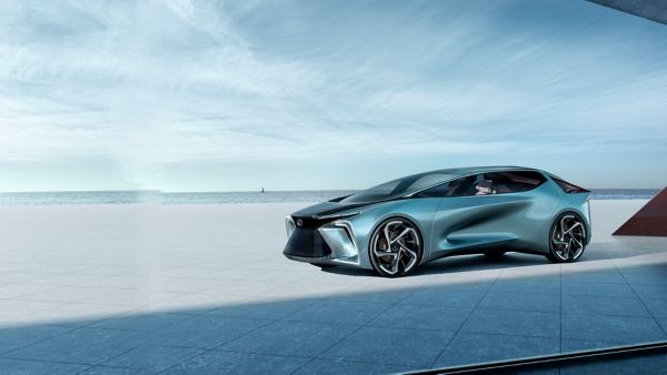 Ein Lexus LF-30 Electrified Konzeptfahrzeug parkt auf einem Platz aus Beton vor einer Meer-Kulisse
