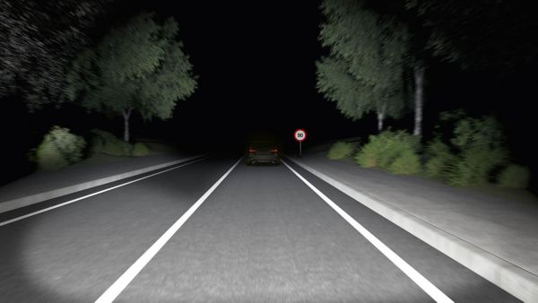 Eine Straßenszene bei Nacht mit klar erkannbarem Verkehrszeichen am Rand