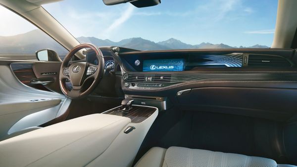 Innenansicht aus Beifahrerperspektive aus einem modernen Lexus mit beleuchteten Armaturen auf ein Bergpanorama