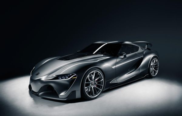 Ein sehr sportlich wirkender, schwarz-silberner Toyota FT1 von schräg vorn, mit einem Spot von oben beleuchtet in einer schwarzen Studioumgebung