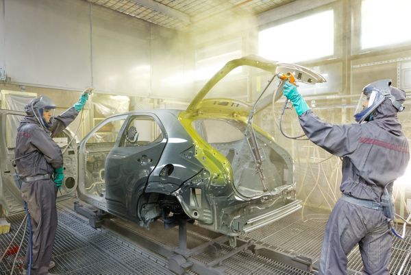 Travailleurs Toyota peignant une carrosserie