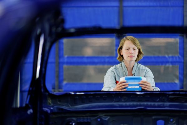 Femme tenant une boîte dans un garage