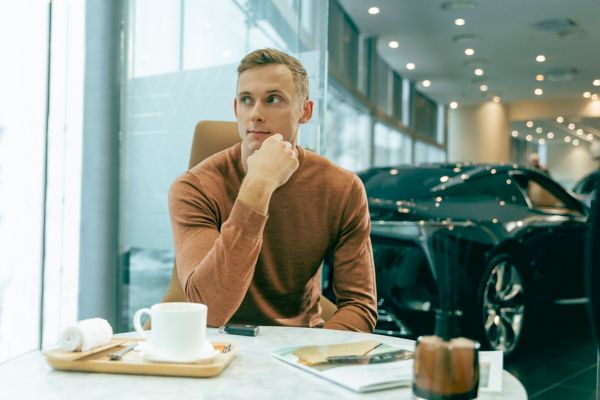 A man and woman sat in a Lexus retailer