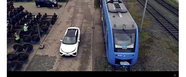 Weißer Toyota Mirai neben einer Blauen Bahn