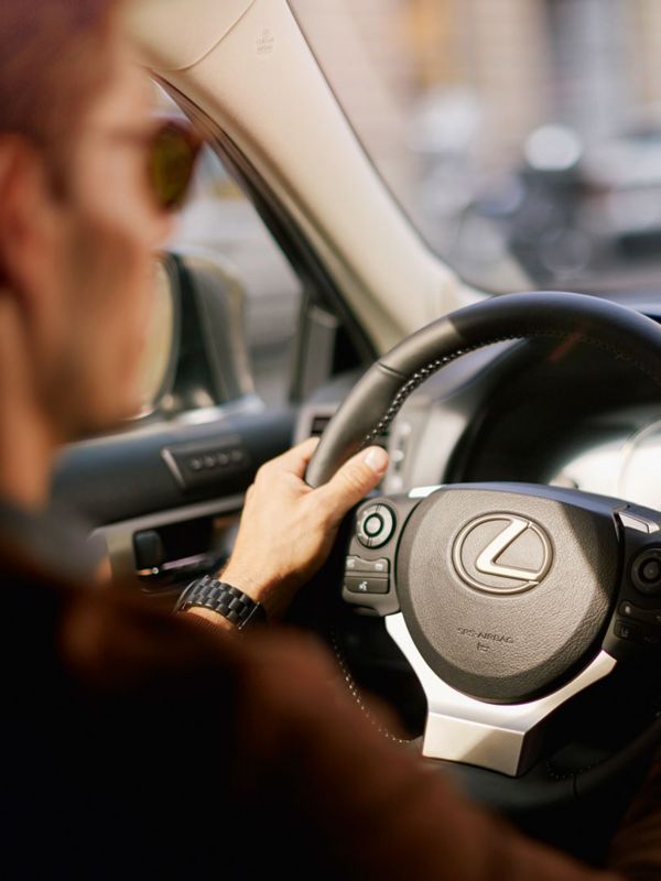 Innenansicht eines Lexus mit einer Person die das Lenkrad hält