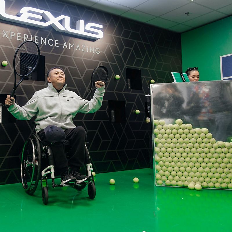 A person in a wheelchair holding a tennis racket