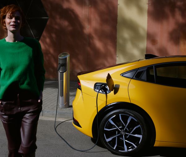 Frau neben einem Prius Plug-in Hybrid