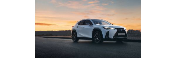 Ein Lexus fährt auf einer Straße im Sonnenuntergang