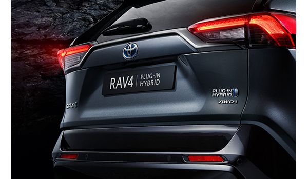 Rückansicht eines Toyota RAV4 Plug-in-Hybrid, mit Hervorhebung des Modellnamens und der Hybrid-Plaketten vor einem dunklen Hintergrund.