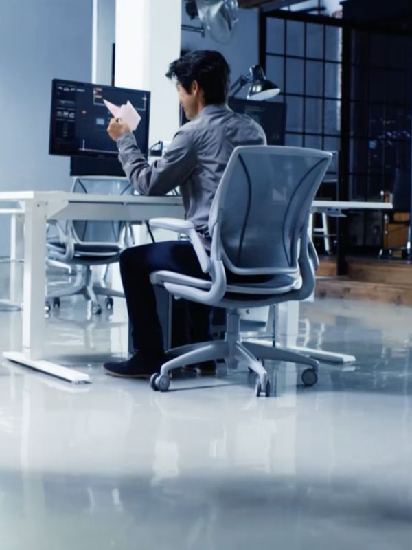 Ein Lexus Takumi Meister sitz vor seinem Computer auf einem Bürostuhl