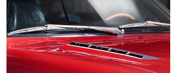 Nahaufnahme der Scheibenwischer und Lüftungsschlitze auf der Motorhaube eines roten Toyota Celica von 1974