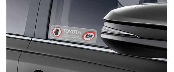 Nahaufnahme einer Autotür mit einem Warnsticker, der Kriminelle davor warnt, dass das Auto einen Toyota dDot-DNA-Diebstahlschutz hat.