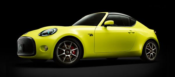 Toyota S-FR in neon-gelb vor schwarzem Hintergrund, mit runden Scheinwerfern und sportlichem Design