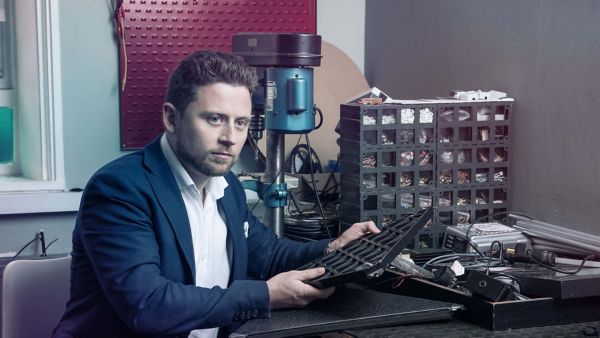Ein Ingenieur sitzt an seinem Arbeitsplatz und prüft Autoteile