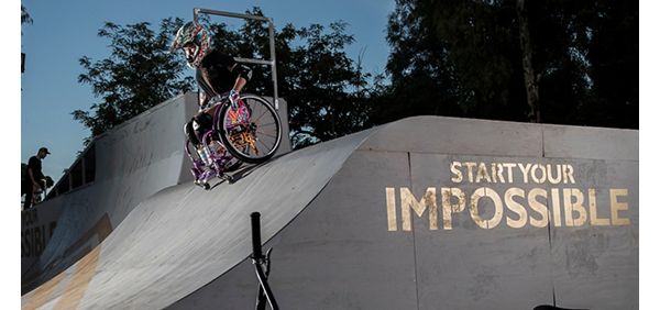 Ein Rollstuhlfahrer fährt eine Halfpipe hinunter