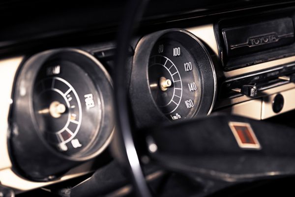 Von Blitzlicht erleuchtete Tachometer eines Toyota Corolla Oldtimers.