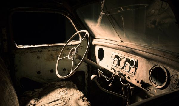 Extrem verwitterter Innenraum des Toyoda AA rustikalem Armaturenbrett, Lenkrad und Schalthebel sowie zerrissenen Stoffresten auf den Sitzen