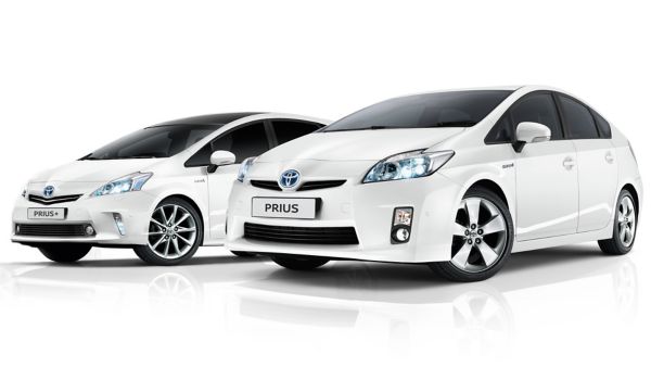 Zwei weiße Toyota Prius-Modelle nebeneinander mit unterschiedlichen Designs und Ausstattungsmerkmalen