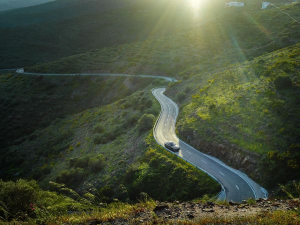 Elektroauto fährt durch grüne Landschaft