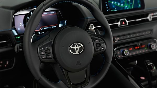 Nahaufnahme eines Toyota-Lenkrads mit Bedientasten und digitalem Armaturenbrett