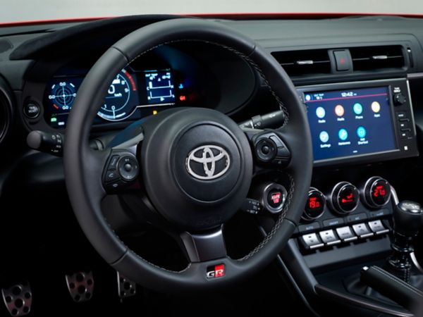 Nahaufnahme eines Toyota-Lenkrads mit Bedientasten und digitalem Armaturenbrett