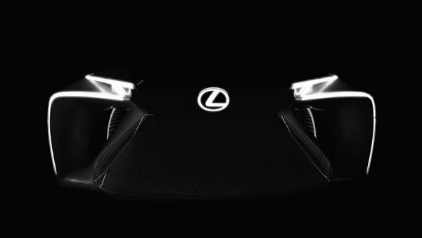 Lexus L Scheinwerfer an im Dunkeln mit leuchtendem Lexus Emblem 