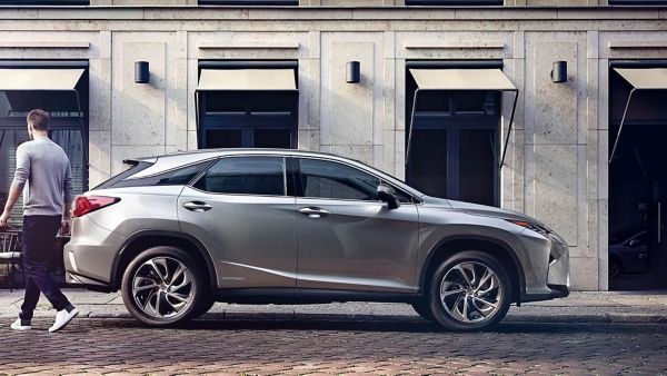 Ein silberner Lexus RX in der Seitenansicht, geparkt vor einem Gebäude