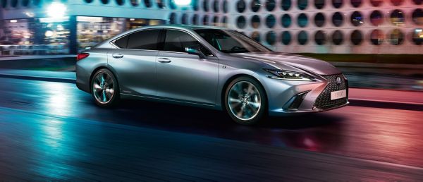 Silberner Lexus fährt durch eine Stadt