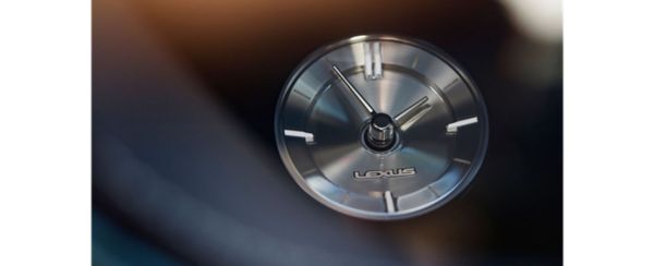 Nahaufnahme der Armaturenbrettuhr eines Lexus LS mit elegantem Silberdesign und dem Lexus-Logo, das die moderne Ästhetik unterstreicht.