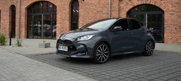 Toyota Yaris zaparkowana obok ceglanego budynku