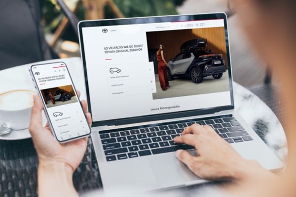 Ein Laptop und ein Smartphone auf einem Tisch, die den Toyota Online Shop geöffnet haben