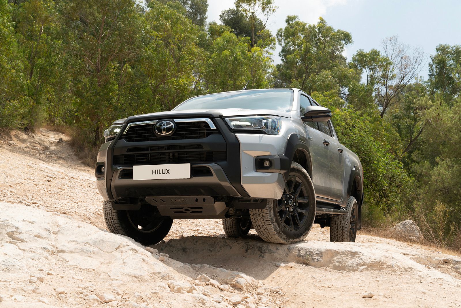 Hilux cruises a sunlit forest track