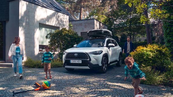 Een Corolla Cross geparkeerd met dakkoffer erop