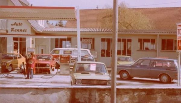 Ein altes Bild von einer Tankstelle mit Fahrzeugen im Hof