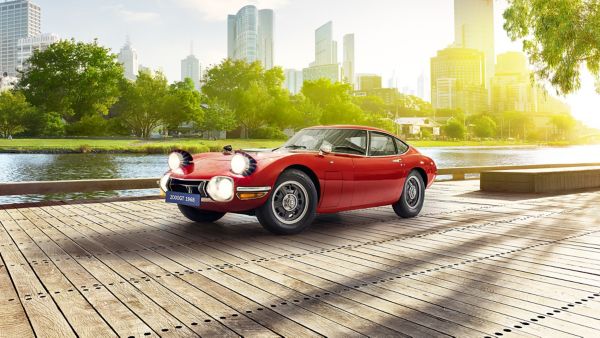 Toyota 2000GT car in red next to other cars