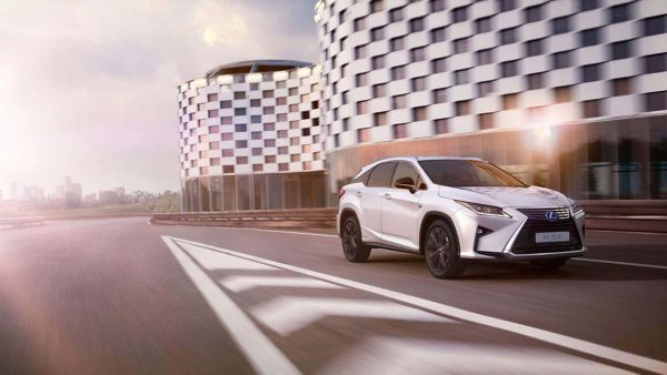 A Lexus with a roof rack driving through a city