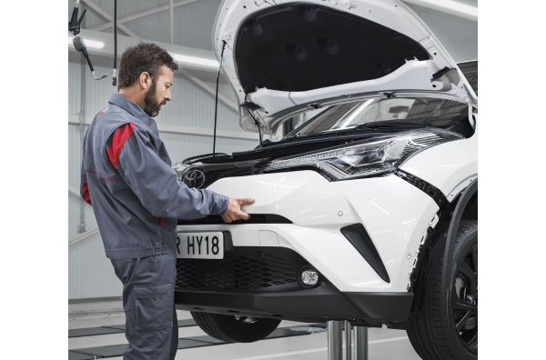 Technician checking car bumper