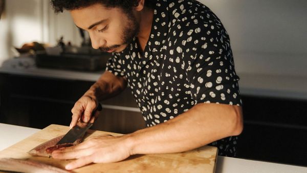 man cutting something on a chopping board