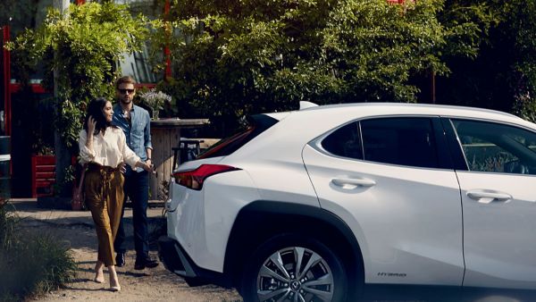 two people walking towards a Lexus car