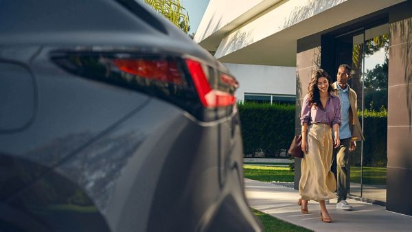 A man and woman walking towards a Lexus NX 