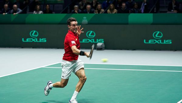 A tennis player serving on a Lexus X ATP court